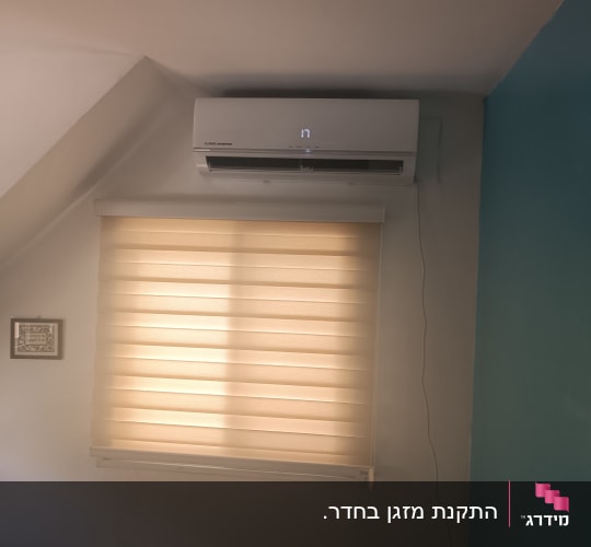 מזגן מותקן מעל חלון עם וילון בחדר שינה